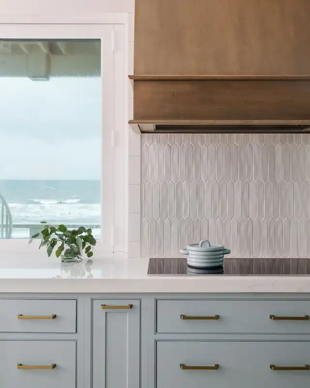 Ponte Vedra kitchen with blue cabinets, gold pulls, white quartz counters and an ocean view window