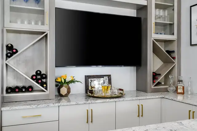Modern wet bar with Eclipse frameless cabinets, granite counters, built-in wine storage and gold hardware