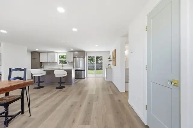 Bright open-concept Jacksonville home with new light wood-look flooring running from the dining area into the kitchen