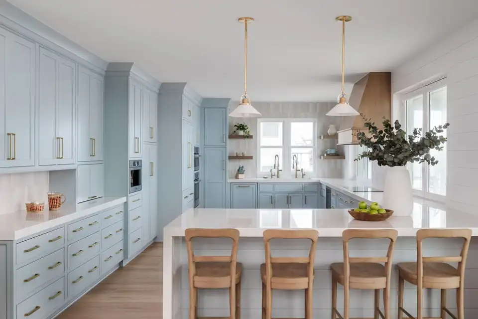 Kitchen remodeling Jacksonville area project in Ponte Vedra: soft blue Shiloh shaker cabinets, brass hardware, a white quartz island and wood counter stools