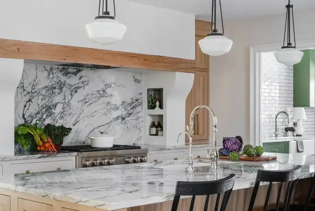 Classic-meets-modern kitchen with a dramatic marble backsplash, stone island and schoolhouse pendants