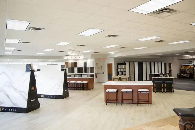 Woodsman showroom in Jacksonville with countertop slab displays, cabinet door samples and a display kitchen island